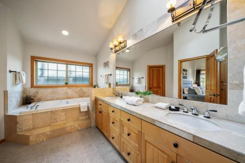 a bathroom with two sinks and a tub and a large mirror at Luxury on Lassen in Sunriver