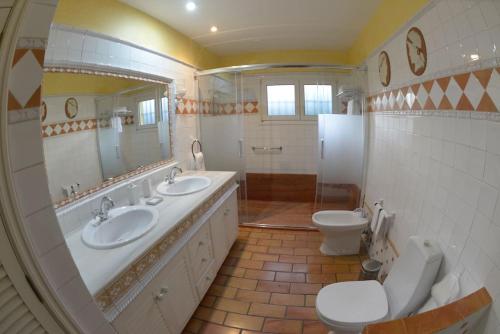y baño con 2 lavabos, aseo y espejo. en Villa Maspalomas Golf Court, en Maspalomas