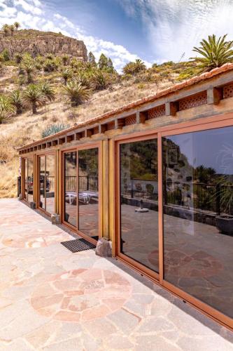 a house with glass doors on a patio at Casa Rural La Palizada in Benchijigua