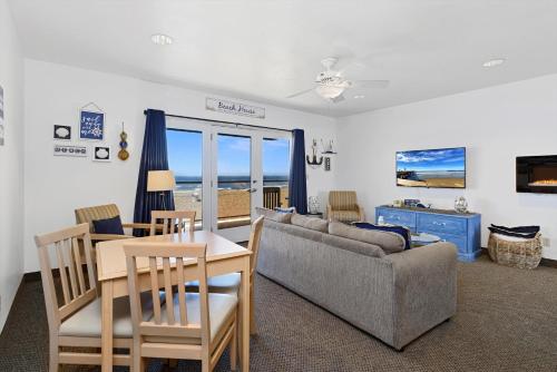 uma sala de estar com um sofá, uma mesa e cadeiras em Beach House Inn & Suites em Pismo Beach