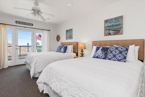 a bedroom with two beds and a ceiling fan at Beach House Inn & Suites in Pismo Beach