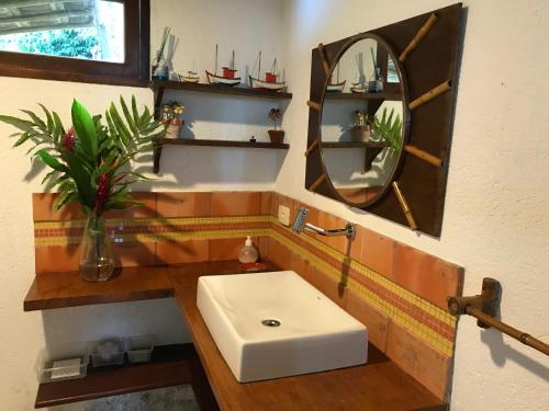 Un baño con un lavabo blanco y un espejo. en Casa na Praia com vista para o mar, en Paraty