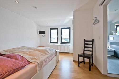 1 dormitorio con 1 cama y 1 silla en Schönblick en Sankt Andreasberg