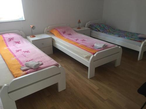 two beds in a room with wooden floors at Apartman SUNCE in Jajce