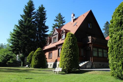 a house with a bench in front of it at Pokoje Gościnne Złota Palma in Lądek-Zdrój