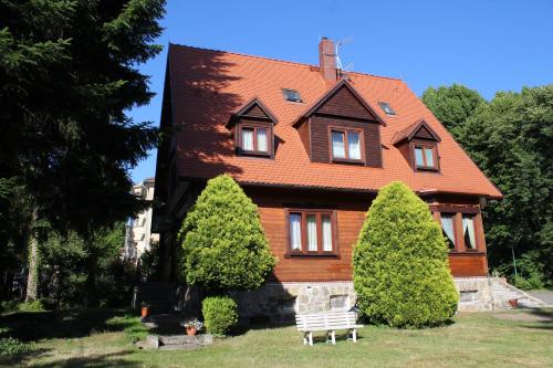 a house with trees in front of it at Pokoje Gościnne Złota Palma in Lądek-Zdrój