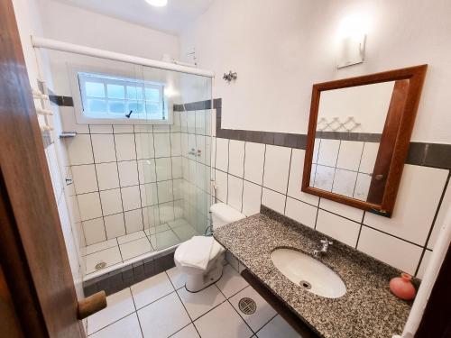 a bathroom with a sink and a toilet and a mirror at Pousada Rumo dos Ventos in Paraty