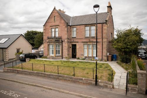 an old brick house on the side of a street at The old church house in Inverness