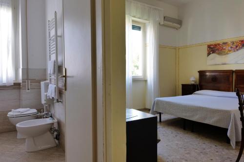 a bathroom with a bedroom with a bed and a toilet at Hotel Club i Pini - Residenza d'Epoca in Versilia in Lido di Camaiore