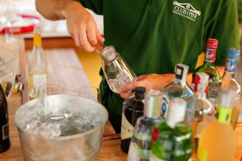 a man pouring a drink in a bucket of ice at Hotel Club i Pini - Residenza d'Epoca in Versilia in Lido di Camaiore