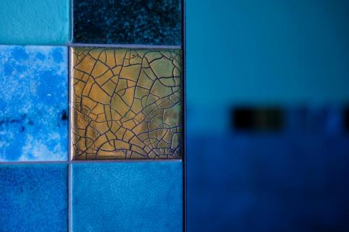 astained glass window in a blue tiled bathroom at Hotel Club i Pini - Residenza d'Epoca in Versilia in Lido di Camaiore