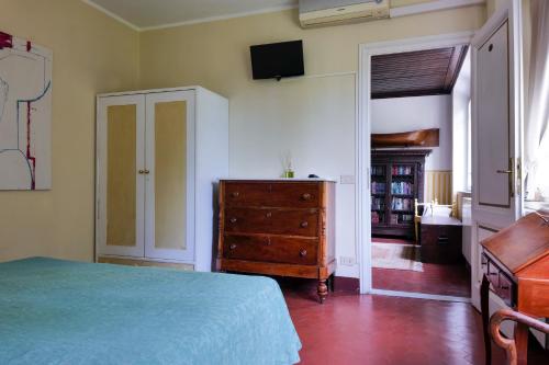 a bedroom with a bed and a dresser and a tv at Hotel Club i Pini - Residenza d'Epoca in Versilia in Lido di Camaiore