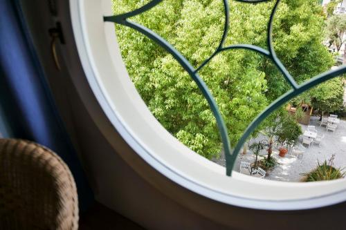 a round window with a view of a garden at Hotel Club i Pini - Residenza d'Epoca in Versilia in Lido di Camaiore