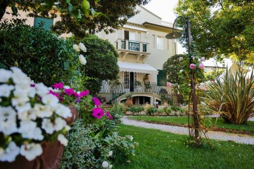 a house with flowers in the front yard at Hotel Club i Pini - Residenza d'Epoca in Versilia in Lido di Camaiore
