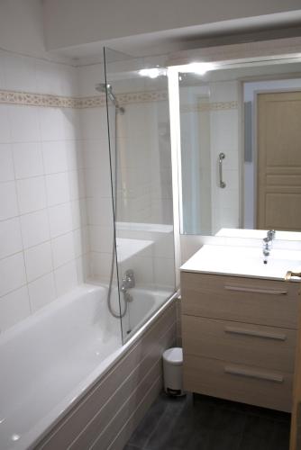une salle de bain avec une baignoire, une douche et un lavabo dans l'établissement Appartement T3 dans résidence 6 pers, à Juzet-de-Luchon