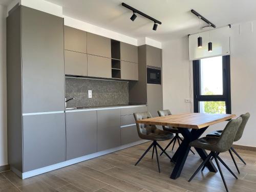 a kitchen with a wooden table and chairs at APARTAMENTOS TURÍSTICOS EL RINCONÍN in Llanes