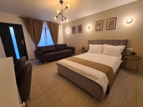 a bedroom with a large bed and a couch at URBANIST Guest House in Călimăneşti