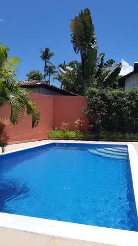 une grande piscine bleue en face d'une clôture dans l'établissement Morena Jambo, à Arraial d'Ajuda