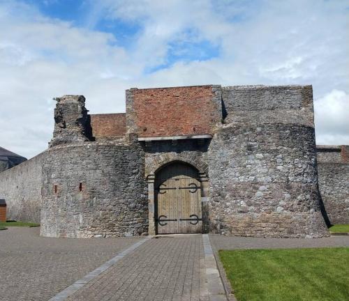 an old stone building with a large door and a brick at Town centre one bed apartment in Dungarvan