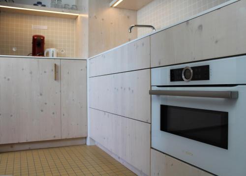 オーステンデにあるCompleet Appartement met Frontaal Zeezicht Oostendeの白いキャビネットとオーブン付きのキッチン