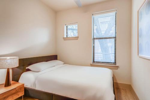 a small bedroom with a bed and two windows at Sentral East Austin at 1630 E Sixth in Austin