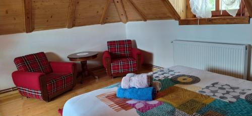 a bedroom with two red chairs and a bed at SVETLA U PLANINI in Bajina Bašta