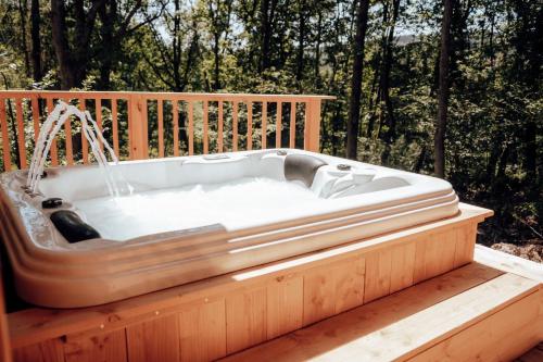 a bath tub sitting on a wooden deck at The WoodPecker Lodge in Waimes