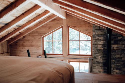 a bedroom with a large window in a attic at The WoodPecker Lodge in Waimes