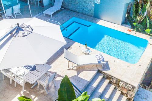 an overhead view of a pool with chairs and an umbrella at Ti’amo in Wilderness