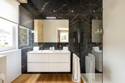 a bathroom with a sink and a mirror at Casa do Desassossego in Monção