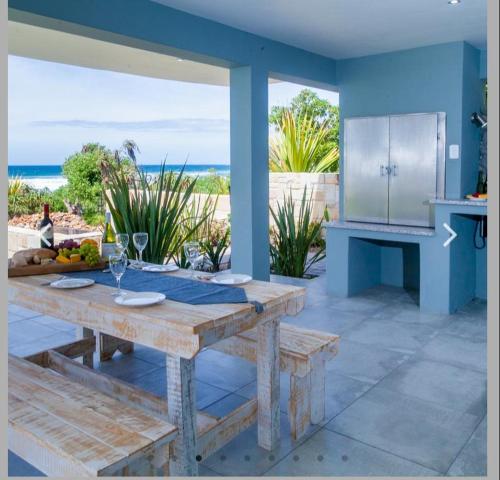 uma mesa de madeira numa cozinha com vista para o oceano em Ti’amo em Wilderness