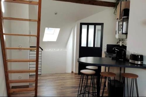 a kitchen with a table and stools in a room at GAP hyper centre Studio atypique 2 personnes. in Gap