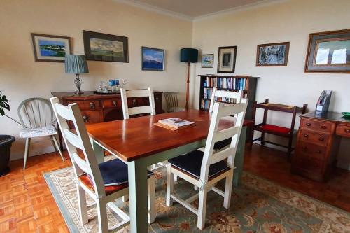 a dining room with a wooden table and chairs at Tobar nan Iasgair Lismore in Achnacroish