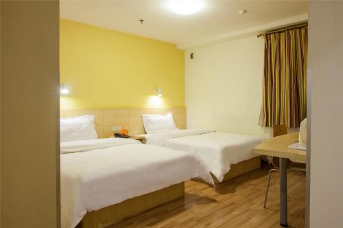 a hotel room with two beds and a desk at 7Days Inn Xi'an North Street Subway Station Lianhu Park in Xi'an