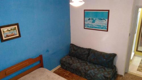 a living room with a couch and a blue wall at Apartamento Praia Grande in Praia Grande