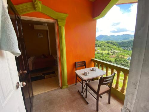 Habitación con balcón con mesa y sillas. en Mountain Palace en Guarata
