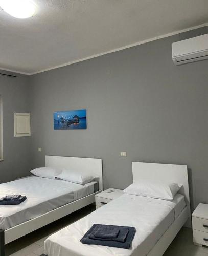 een slaapkamer met 2 bedden en een blauwe muur bij B&B Blu Krimisa in Cirò Marina