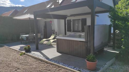 a bathroom with a tub and a deck with plants at The Primevères Home - SPA in Sainte-Marie-aux-Mines