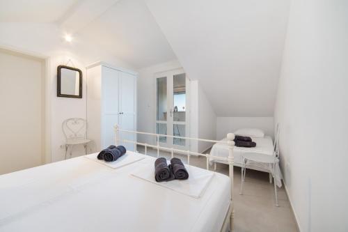 ein weißes Schlafzimmer mit 2 Betten und 2 Stühlen in der Unterkunft Eco Villa with Pool in Podaca