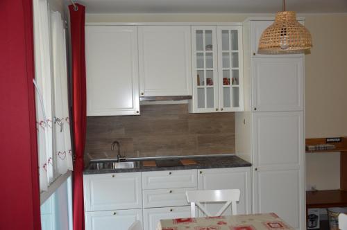 eine Küche mit weißen Schränken und einem Waschbecken in der Unterkunft LA CASA DEL GUARDIA in Lonedo