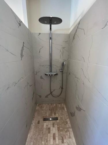 a bathroom with a shower with a tiled wall at L’escale du Roy : maison récente proche versailles in La Queue-lès-Yvelines