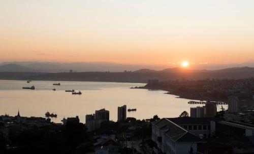 a view of a river at sunset with boats in it at Hotel Faro Azul Valparaíso Cerro Alegre in Valparaíso
