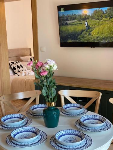 a table with blue and white plates and flowers on it at Anielski Zakątek Solina - balia z jacuzzi i sauna w cenie pobytu in Solina