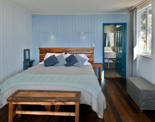um quarto com uma cama grande e paredes azuis em Hotel Faro Azul Valparaíso Cerro Alegre em Valparaíso