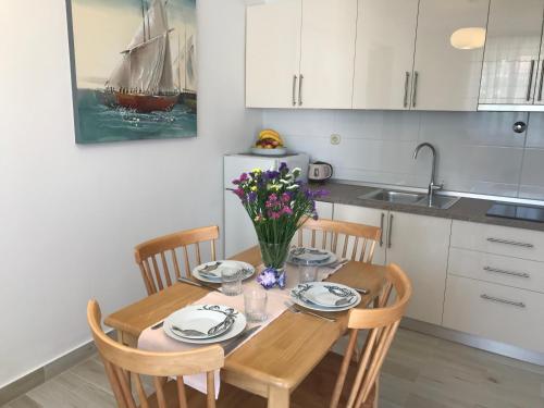 a kitchen with a wooden table with chairs and a dining room at Apartments Sunny Elza in Hvar