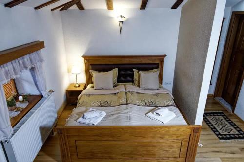 a bedroom with a bed with two towels on it at The House of the Miyaks in Rostuša