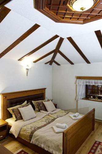 a bedroom with two beds in a room with wooden ceilings at The House of the Miyaks in Rostuša