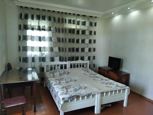 Roin Guest House في غريغوليتي: غرفة نوم بسرير ابيض ونافذة