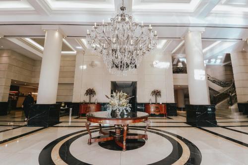 a large lobby with a table and a chandelier at DiplomaticHotel in Mendoza