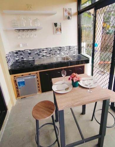 a kitchen with a wooden table with chairs and a sink at Palompon kalimba de luna Villa Inn in Leyte